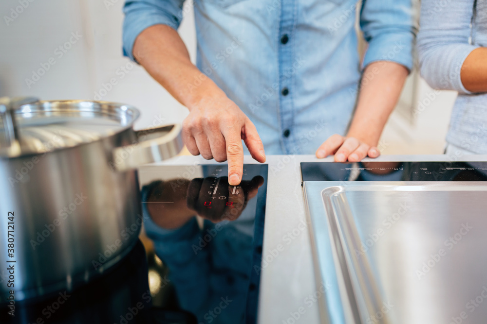 Crop man turning on stove under saucepan Crop man turning on stove under saucepan