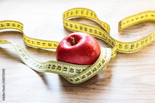 A red Apple is measured by a meter. Slimness and diet.
