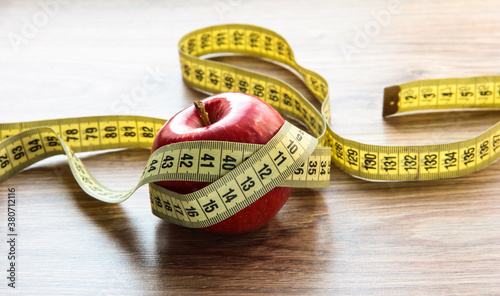 Photos A red Apple is measured by a meter. Slimness and diet.