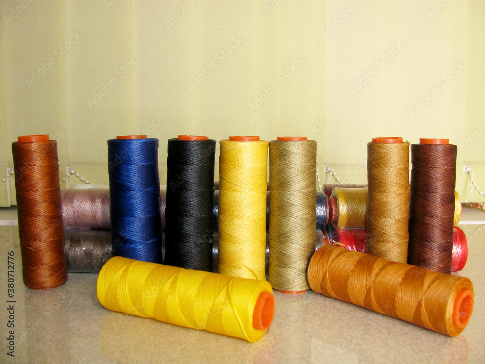 A set of multi-colored thick yellow, brown, black, blue threads for sewing leather products. A set of multi-colored thick yellow, brown, black, blue threads for sewing leather products.