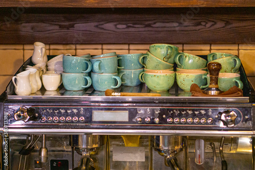 colored cups stacked on a coffee maker with other accessories. copy space