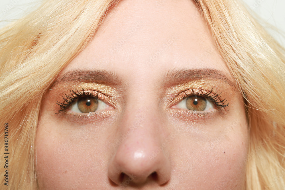 Mirada hacia el horizonte de chica de ojos marron claro con maquillaje dorado Mirada hacia el horizonte de chica de ojos marron claro con maquillaje dorado
