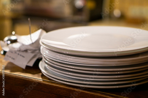 clean plates stand on a wooden bar near the checks/ copy space