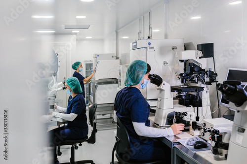 Biologists working on microscope in IVF laboratory photo