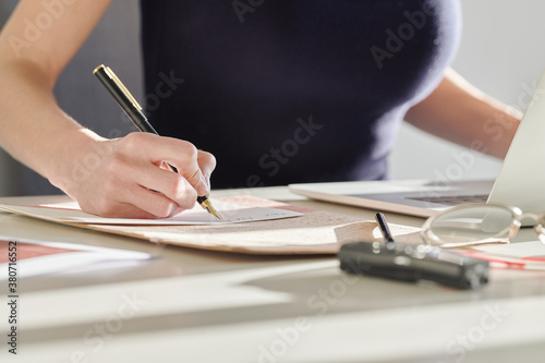 Business woman writing in notebook with ink pen