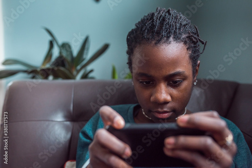 Portrait of a black girl playing games on her mobile device