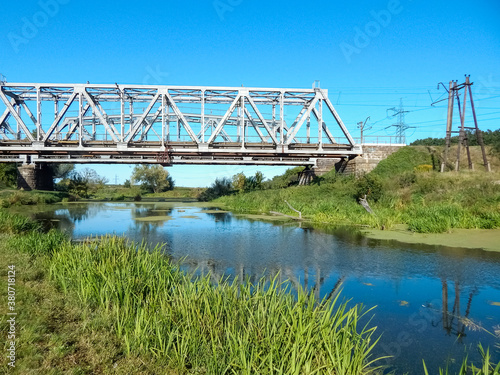Steel railway bridge over the river, countryside landscape, sunny day