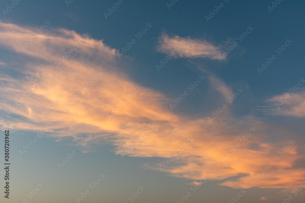 Naklejka premium Sunset colorful epic colorful golden clouds on blue vivid sky. Magic dusk light cloudscape