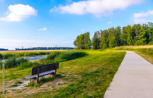 A bench on the park with blue sky with few clouds © sajiths