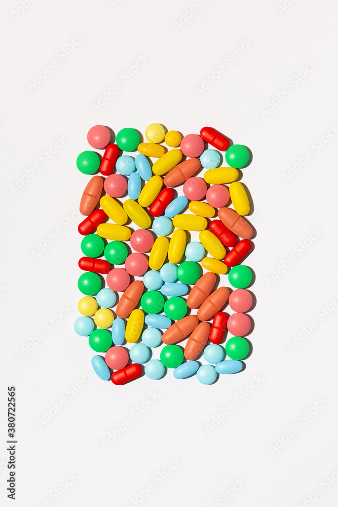 Scattered colorful pills against white background Scattered colorful pills against white background
