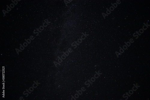 Starry night black sky fully with glowing stars of Milky way. Real astro photo on summer night.