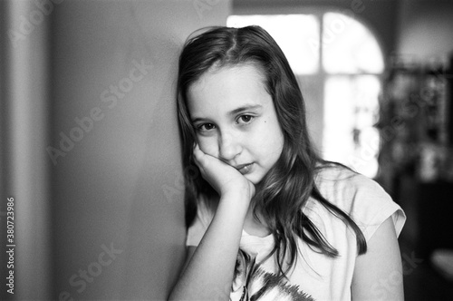 Cute young girl resting her head again a wall