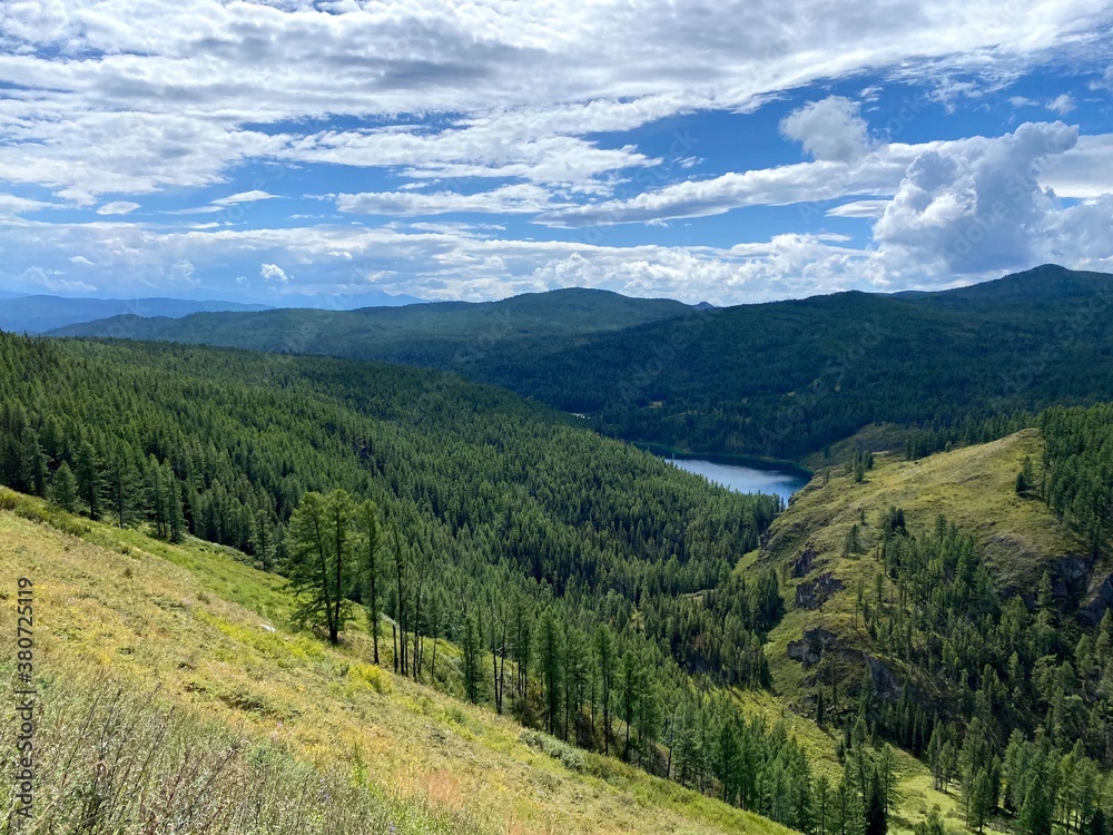 Mountain landscape in nature in the open air depicting clouds, conifers and meadows Mountain landscape in nature in the open air depicting clouds, conifers and meadows
