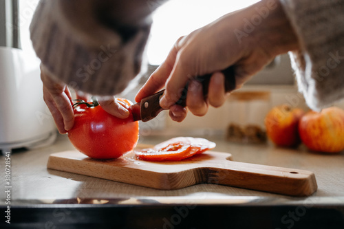 Anonymous woman cutting a tomato photo