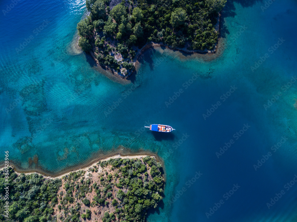 A boat floats between two islands A boat floats between two islands