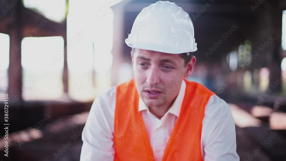 Construction engineer in a hard hat is at loss. Fired from work, the company is bankrupt. The psychological state of a man's frustration. Construction engineer in a hard hat is at loss. Fired from work, the company is bankrupt. The psychological state of a man's frustration.