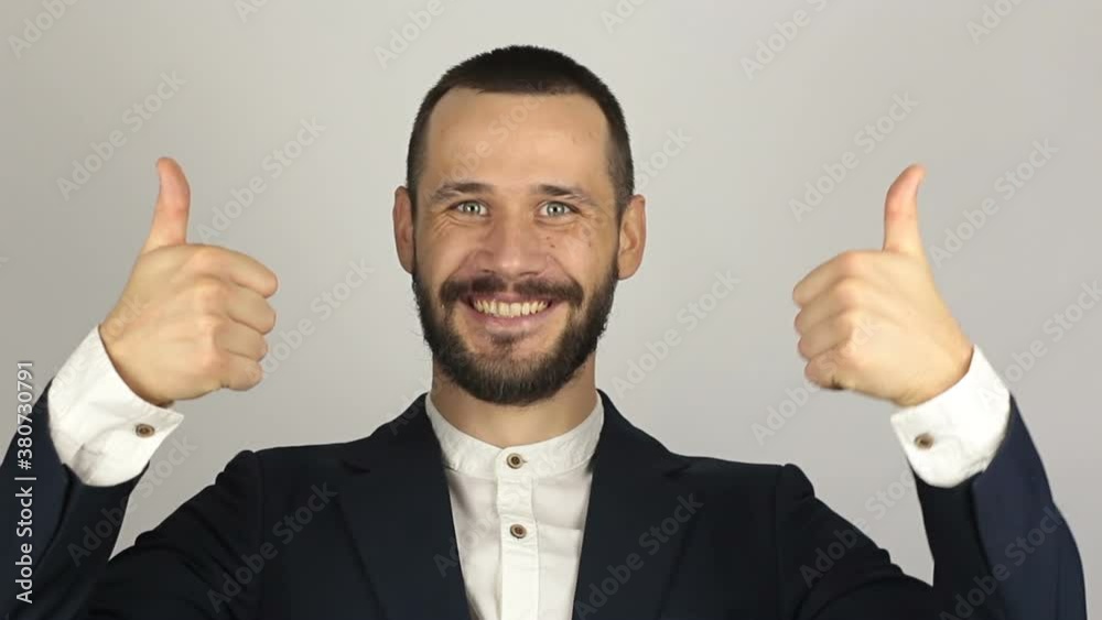 Young handsome businessman is smiling and showing thumb up with two hands. Young handsome businessman is smiling and showing thumb up with two hands.