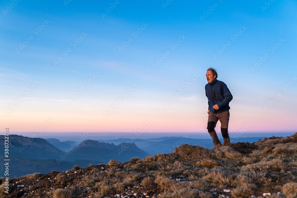 man running on rugged top of mountain man running on rugged top of mountain