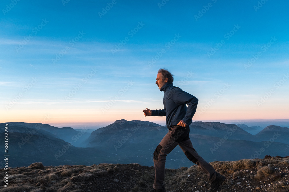 man running on rugged top of mountain man running on rugged top of mountain