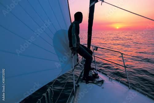 sailor absorbing the sunset at sea photo