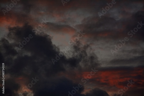 Black wispy clouds and red skies at sunset in Autumn