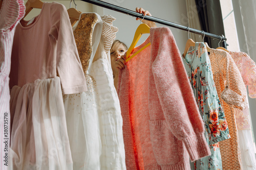 Girl choosing dresses on a clothing rack