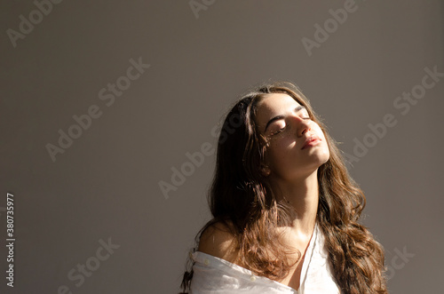 Young woman with long hair sitting on a chair photo
