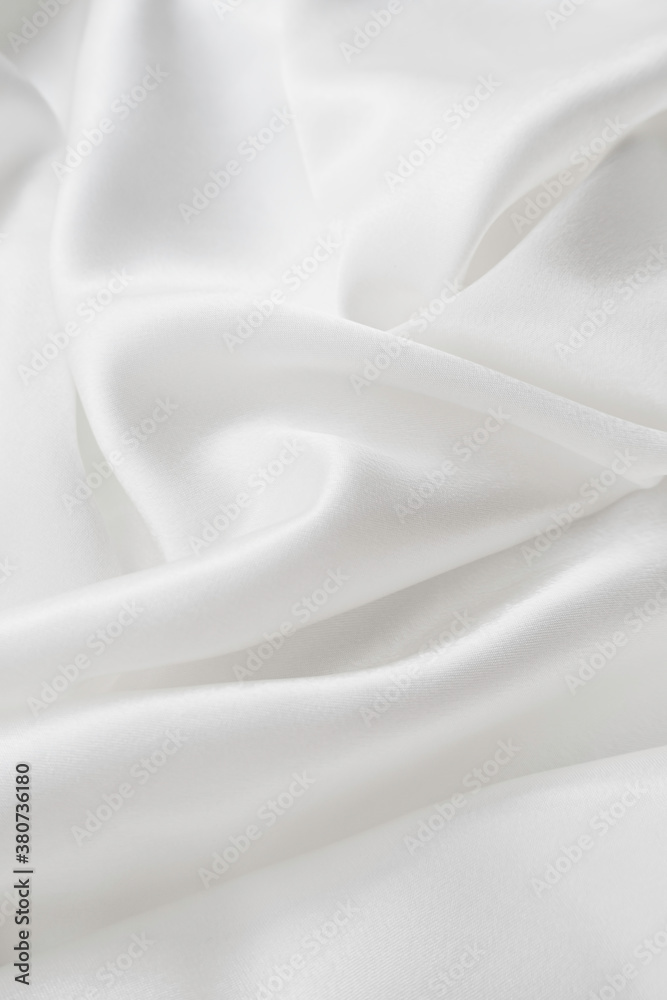 smooth folds of white fabric. horizontal orientation, soft focus. elegant fabric background