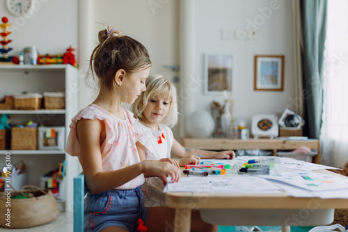 Two little girls coloring at home photo