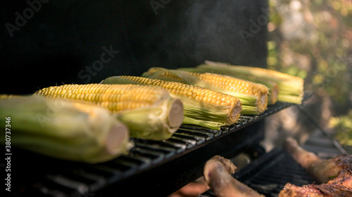 Chef cooking BBQ with a corn on the cob on grilled. Delicious corns on barbecue.