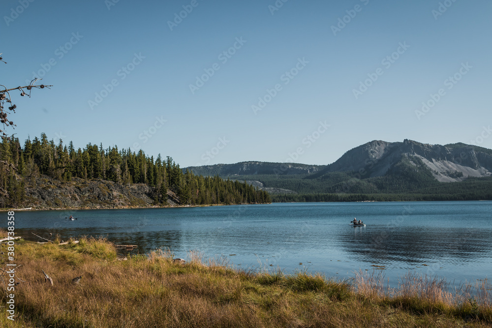 people kayaking on lake and near the mountains