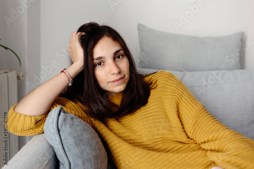 Young woman in yellow looking at camera photo