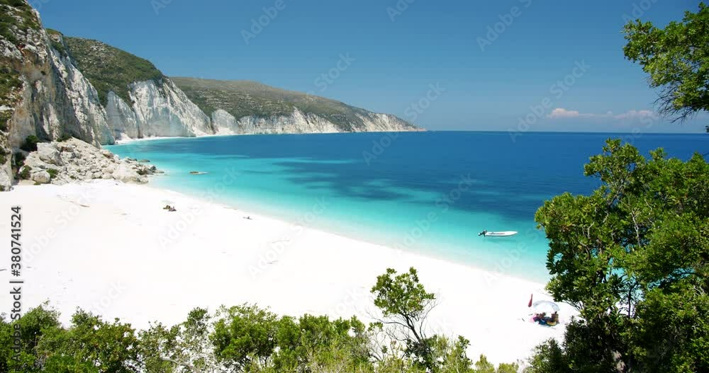 Secluded Fteri beach on Keflaonia Island, Greece. White rocks and blue lagoon surrounded by green foliage Secluded Fteri beach on Keflaonia Island, Greece. White rocks and blue lagoon surrounded by green foliage