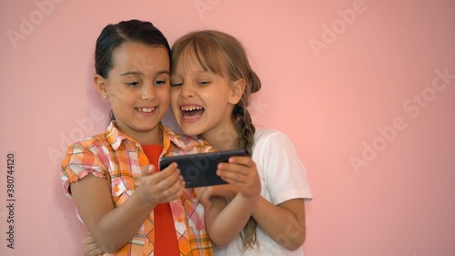 two little girls taking photo with a smartphone