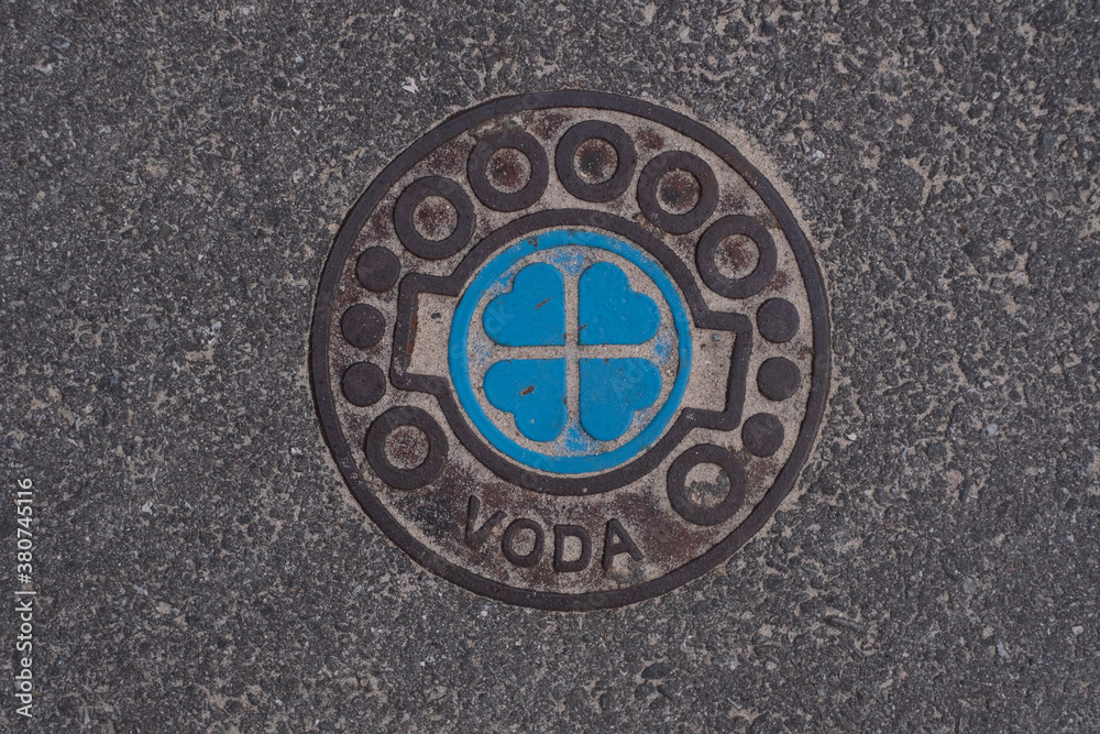 Water line cover on a street with beautiful hearts design and text 