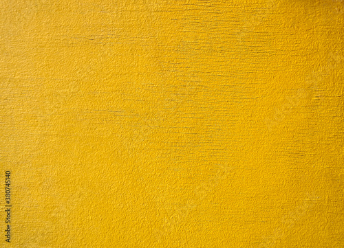 The wooden wall is covered with yellow paint. Traces of the effects of atmospheric precipitation are visible.