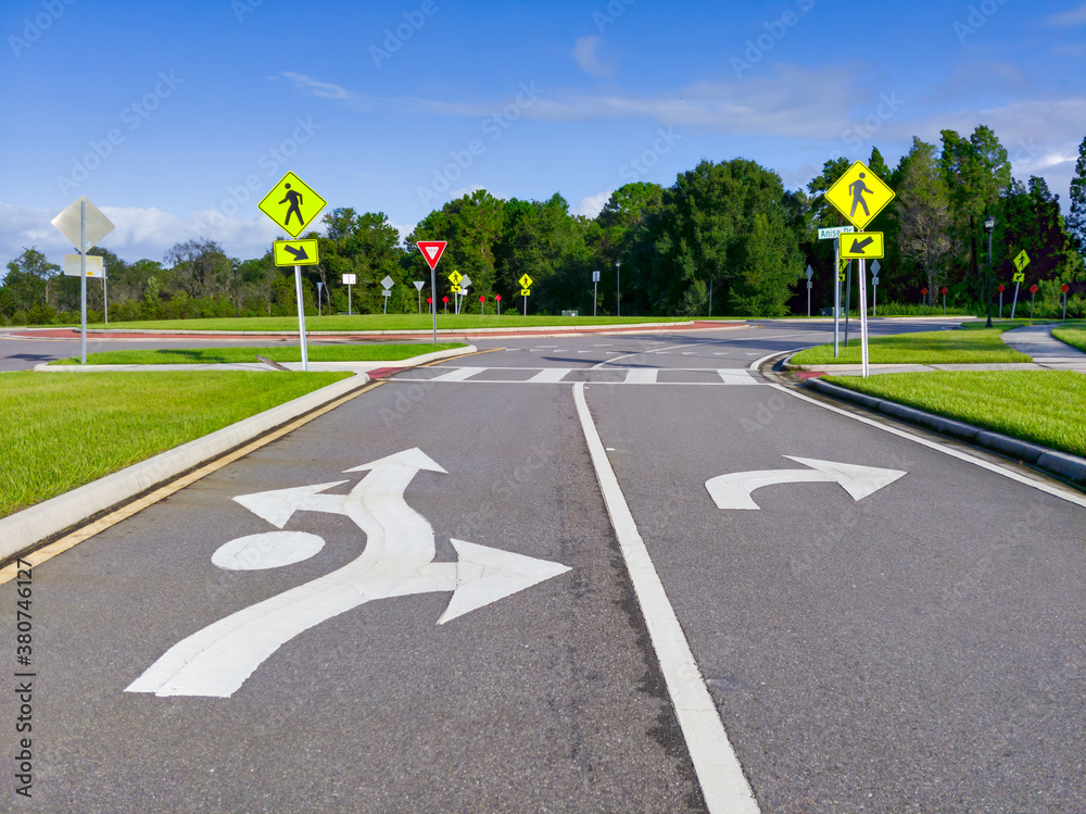 Fototapeta premium Cluster of Street Signs and road marking at a roundabout in Wesley Chapel, Florida