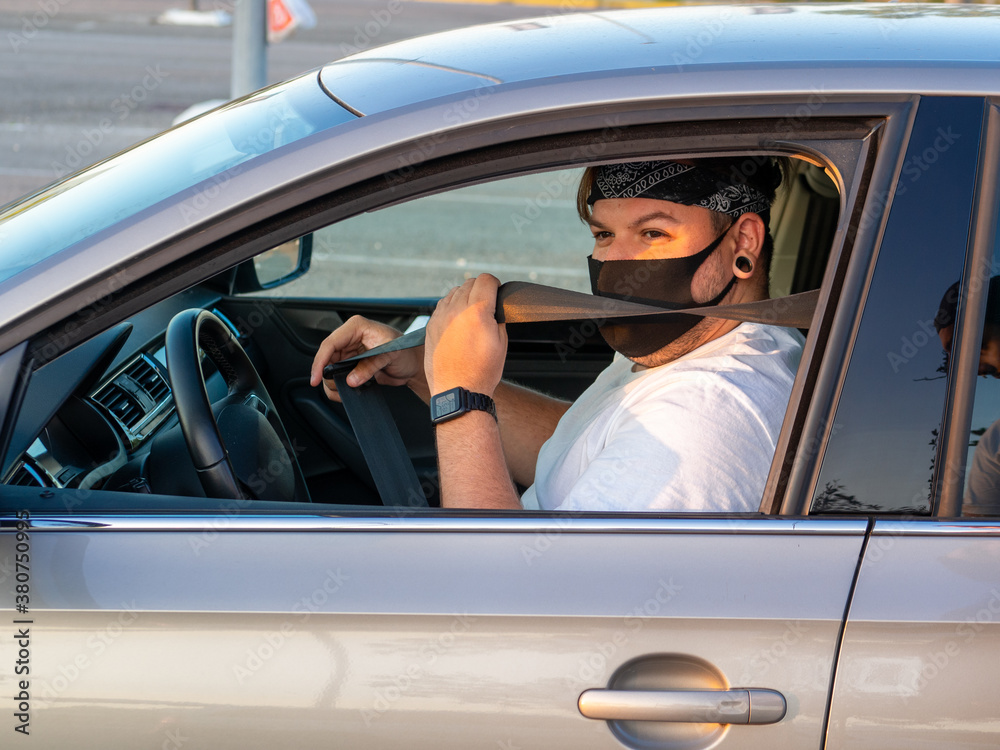 Naklejka premium Hombre joven poniéndose el cinturón de seguridad