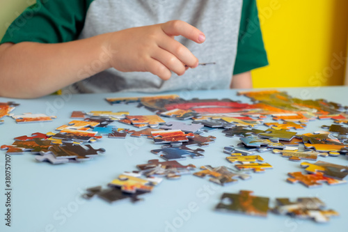 close up of a child's hand holding a puzzle. Early learning.