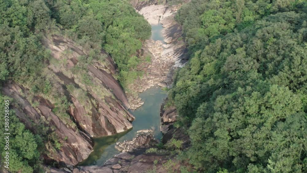 Aerial view of a small dried mountain river bed, with forest on its sides. China. Aerial view of a small dried mountain river bed, with forest on its sides. China.