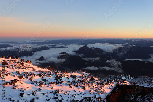 View from the snowy summit at sunrise: mountains top above the clouds. Cloud bed in the Andes. Neuquen, Argentina