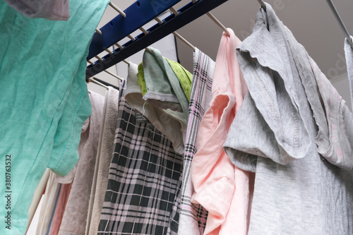 Fresh washed linen, clothes hanging on a dryer, dry apparel on a folding portable dryer close up, housekeeping, homework and chores concept