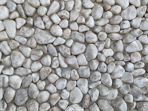 Abstract background texture created by small  light-colored pebbles