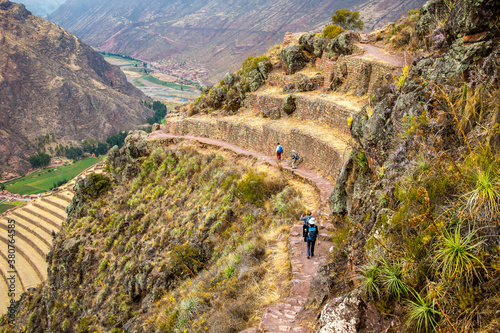 Pisac, Peru - 11/1/2015:  Hikers on the Inca trail, passing by the Parque Archaeology site (Inca ruins)  near Pisac,. photo