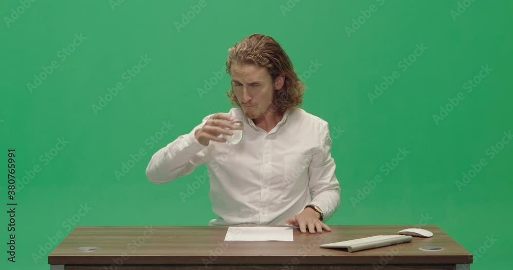 Studio, slow motion, green screen, a young male newscaster drinks water, London, UK Studio, slow motion, green screen, a young male newscaster drinks water, London, UK