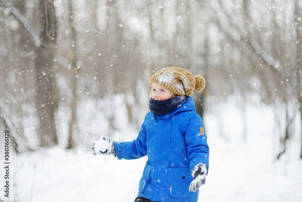 Little boy having fun playing with fresh snow. Active outdoors leisure for child in snowy winter day. Little boy having fun playing with fresh snow. Active outdoors leisure for child in snowy winter day.