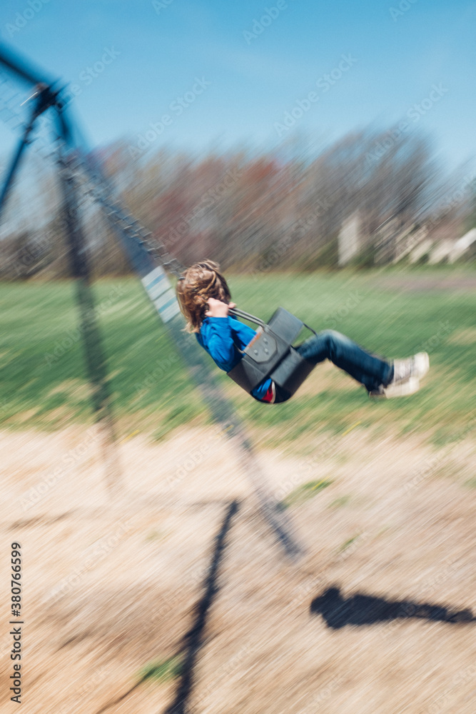 Child swinging in the spring with motion blur Child swinging in the spring with motion blur