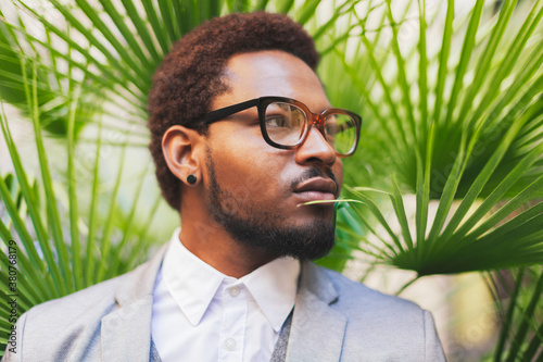Portrait of african american businessman in front green palm leaves.