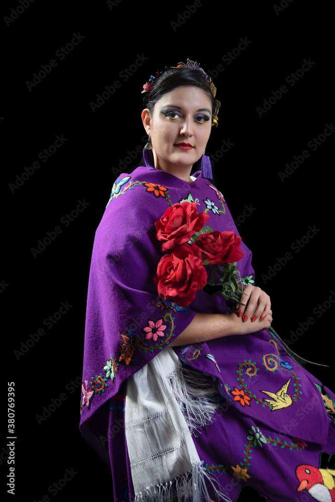 Mujer latina portando un traje representativo del estado de Mexico, en color morado con flores bordadas a mano, con rosas rojas, retrato con fondo negro Mujer latina portando un traje representativo del estado de Mexico, en color morado con flores bordadas a mano, con rosas rojas, retrato con fondo negro