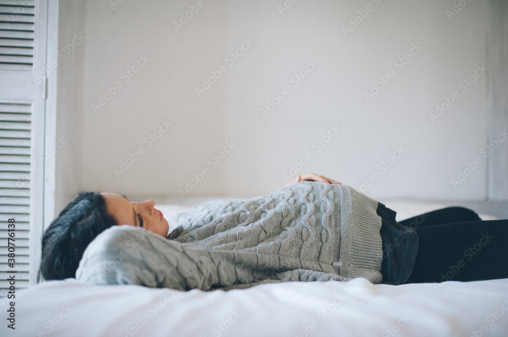Pregnant woman lies on bed Pregnant woman lies on bed